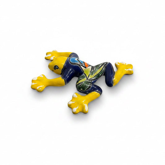 Colorful ceramic frog figurine on a light surface